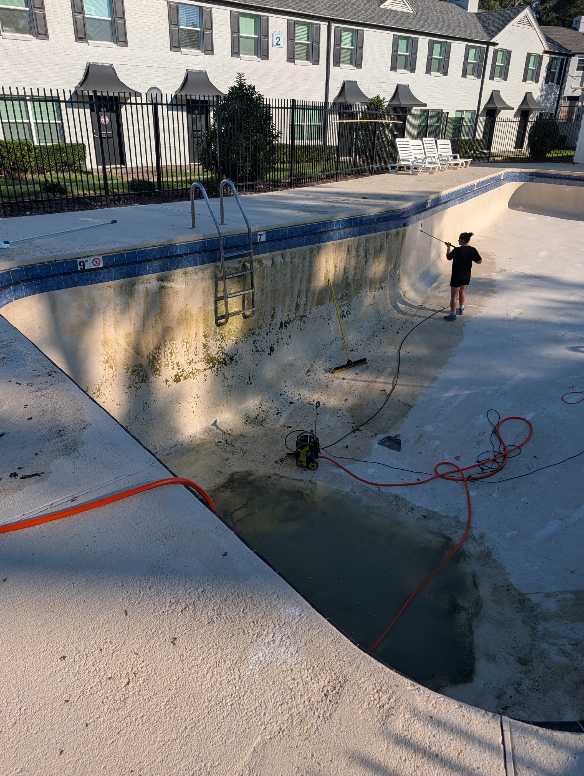 Pressure washing a drained pool in Shreveport