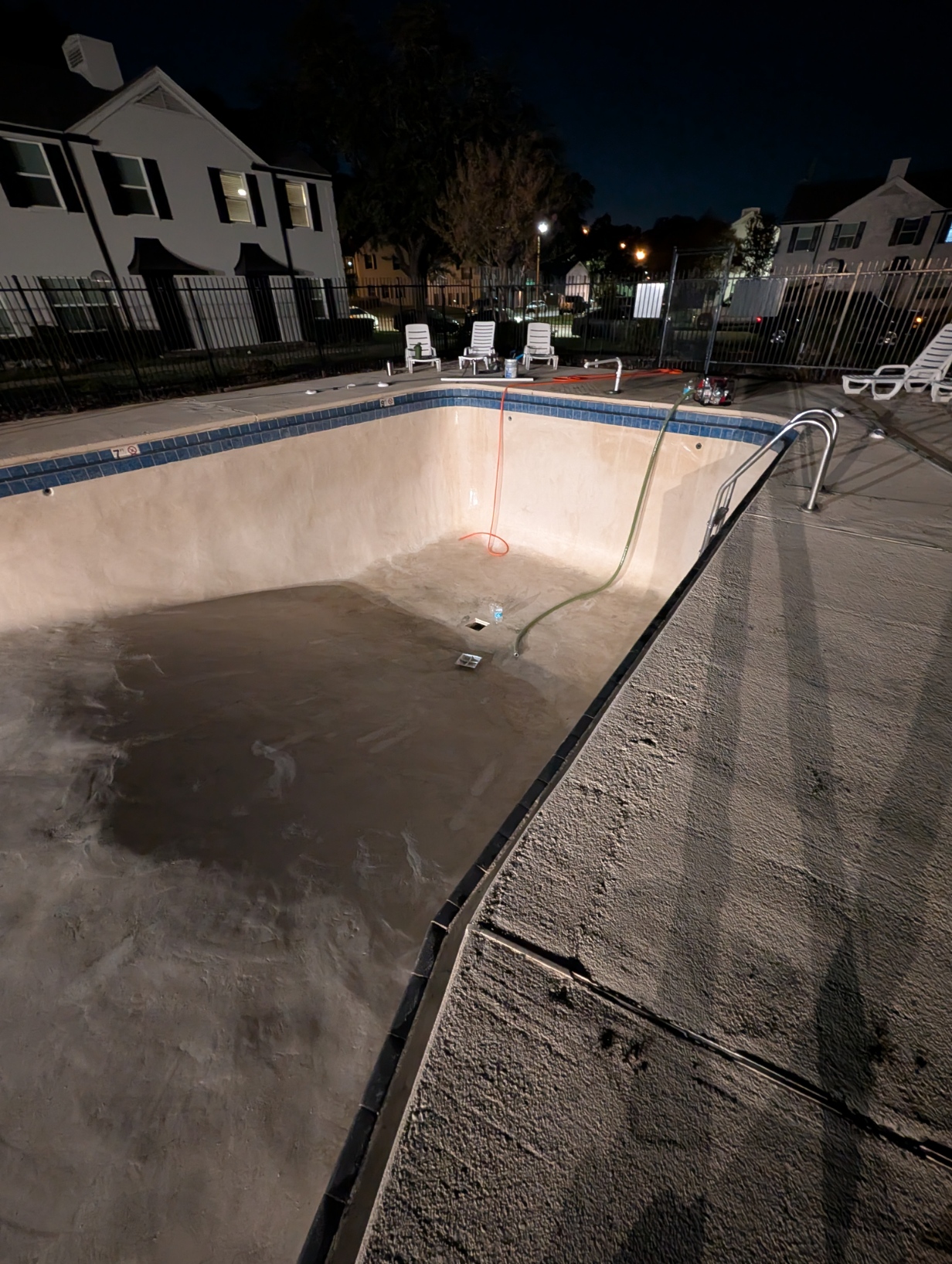 Pressure washing a drained pool in Shreveport