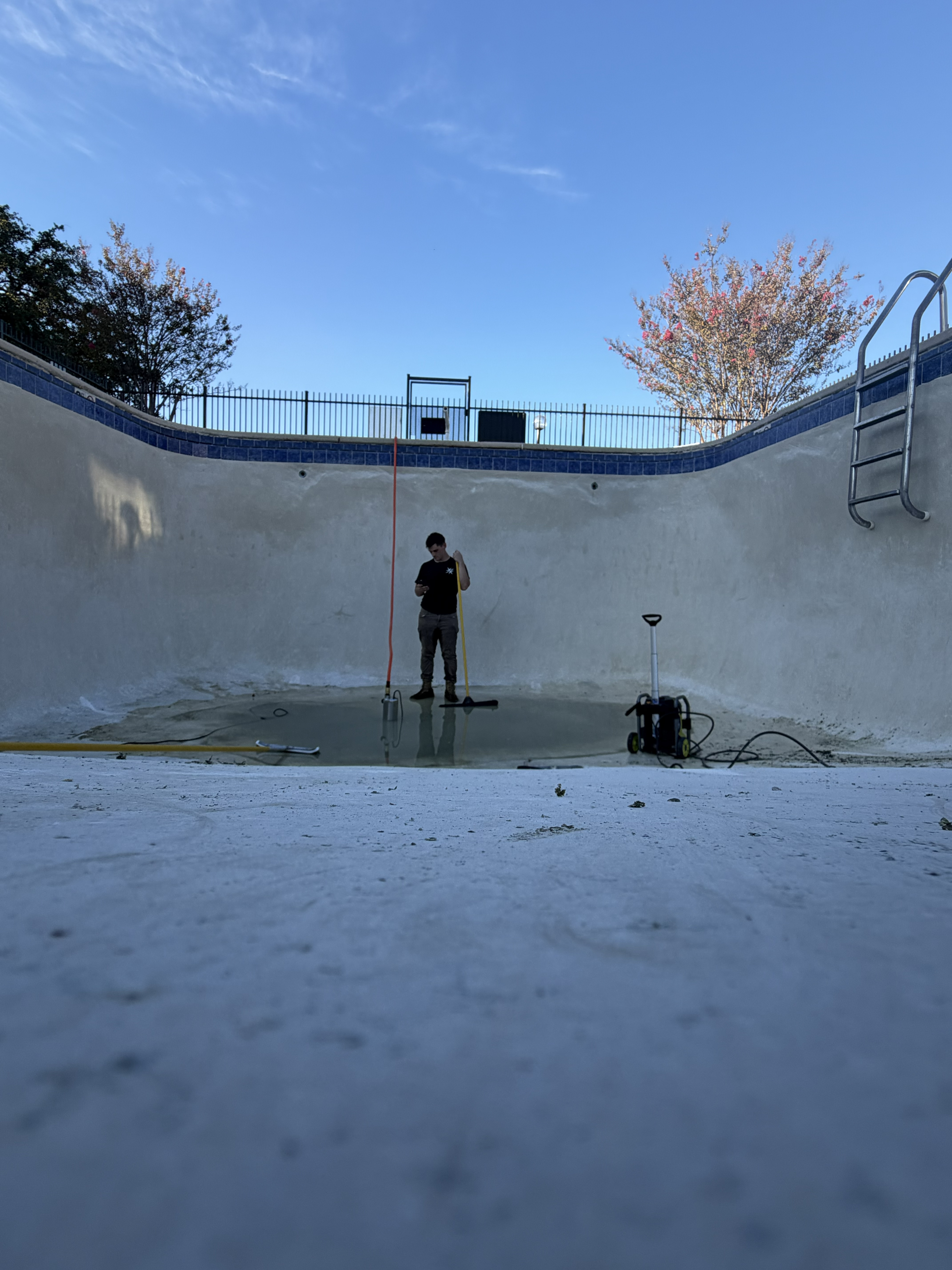 Pressure washing a drained pool in Shreveport